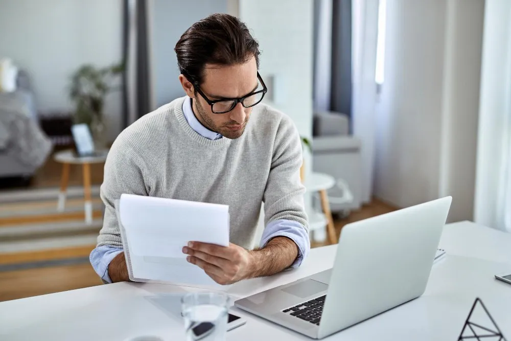 Un jeune homme d'affaires effectue des formalités et utilise un ordinateur portable